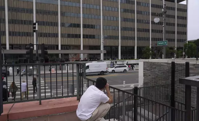 People line up outside the Los Angeles Federal Building in Los Angeles, housing the U.S. Immigration and Customs Enforcement (ICE) and U.S. Citizenship and Immigration Services (USCIS) on Wednesday, June 25, 2025. (AP Photo/Damian Dovarganes)