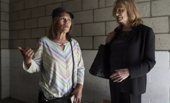 Som Xin, originally from Laos, inquires about hiring immigration Attorney Kim Carver as she exits the ICE Los Angeles Staging Facility, while trying to find her boyfriend's location after he was detained by federal agents in Los Angeles, on Wednesday, June 25, 2025. (AP Photo/Damian Dovarganes)