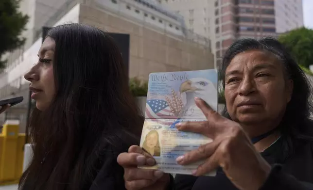 Margarita Velez, mother of Andrea Velez, 32, a U.S. citizen of South L.A, pictured on her current U.S. passport, is joined by her younger, daughter, Estrella Rosas, 17, left, looking for her location after ICE agents detained Andrea Velez during an immigration raid in downtown, outside the Metropolitan Detention Center in Los Angeles on Wednesday, June 25, 2025. (AP Photo/Damian Dovarganes)