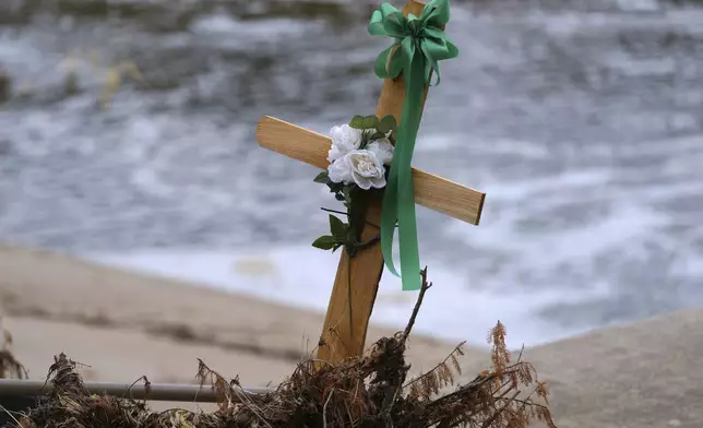 A cross stands in debris at a make-shift memorial honoring flood victims, Sunday, July 13, 2025, in Kerrville, Texas. (AP Photo/Eric Gay)
