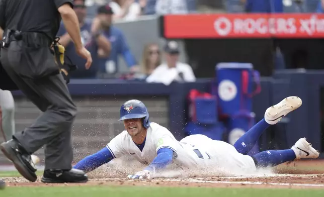 Toronto Blue Jays third base Ernie Clement (22) is safe at home plate during sixth inning MLB action against the San Francisco Giants in Toronto on Saturday, July 19, 2025. (Nathan Denette/The Canadian Press via AP)