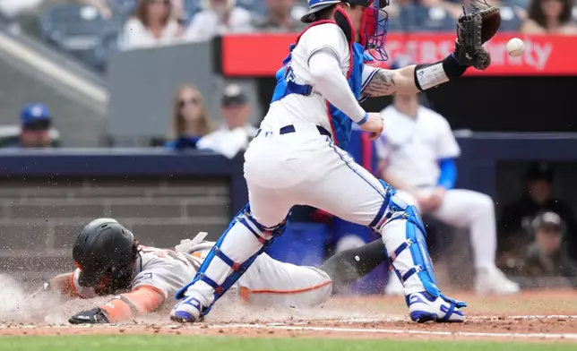 San Francisco Giants outfielder Luis Matos (29) is safe at home plate pass Toronto Blue Jays catcher Tyler Heineman (55) during sixth inning MLB action in Toronto on Saturday, July 19, 2025. (Nathan Denette/The Canadian Press via AP)