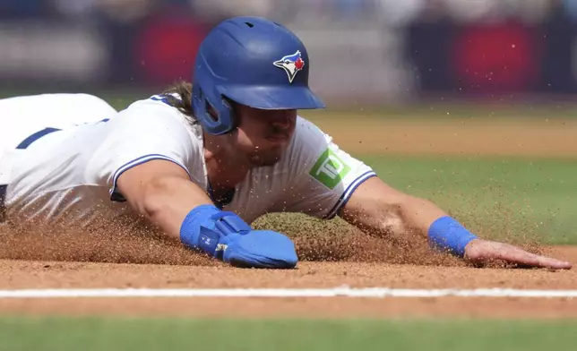 Toronto Blue Jays third base Addison Barger (47) slides safely into third base during fourth inning MLB baseball action against the San Francisco Giants in Toronto on Saturday, July 19, 2025. (Nathan Denette/The Canadian Press via AP)