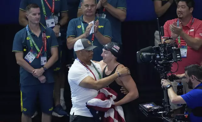 Katie Ledecky of the United States, right, celebrates with her coach Anthony Nesty after winning gold medal in the women's 1500m freestyle final at the World Aquatics Championships in Singapore, Tuesday, July 29, 2025. (AP Photo/Lee Jin-man)