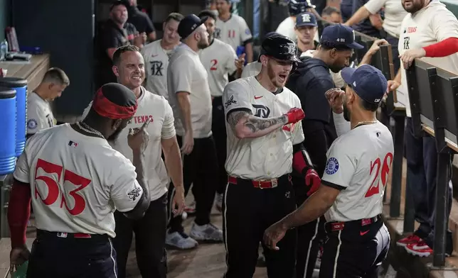 Texas Rangers' Adolis Garcia (53), Jonah Heim, center right, and Ezequiel Duran (20) celebrate Heim's solo home run in the second inning of a baseball game against the Atlanta Braves Friday, July 25, 2025, in Arlington, Texas. (AP Photo/Tony Gutierrez)