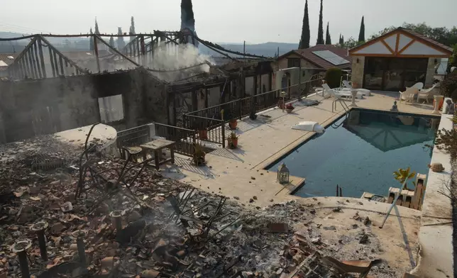Burned houses are seen in Souni village, Cyprus, during a massive wildfire on the southern side of the east Mediterranean island nation's Troodos mountain range, Thursday, July 24, 2025. (AP Photo/Petros Karadjias)