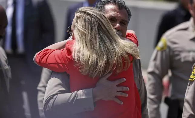 Los Angeles County Sheriff Robert Luna gets a hug from Supervisor Kathryn Barger as he arrives for a press conference after three members of the department were killed in an explosion at a training facility on Friday, July 18, 2025, in Los Angeles. (AP Photo/Etienne Laurent)