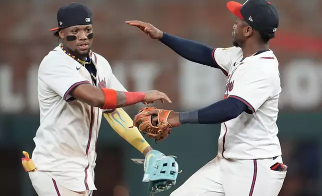 Atlanta Braves' Ronald Acuña Jr. and Ozzie Albies, from left, celebrate a win over the San Francisco Giants inning of a baseball game, Monday, July 21, 2025, in Atlanta. (AP Photo/Mike Stewart)