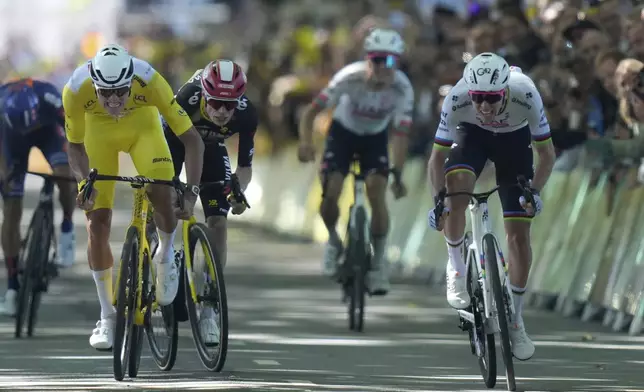 Slovenia's Tadej Pogacar right, and Netherlands' Mathieu van der Poel wearing the overall leader's yellow jersey sprint to the finish line during the fourth stage of the Tour de France cycling race over 172.2 kilometers (107 miles) with start in Amiens and finish in Rouen, France, Tuesday, July 8, 2025. (AP Photo/Mosa'ab Elshamy))