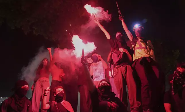 People light flares during a protest called by main opposition Republican People's Party or (CHP), outside the City Hall in Istanbul, Turkey, Tuesday, July 1, 2025. (AP Photo/Francisco Seco)