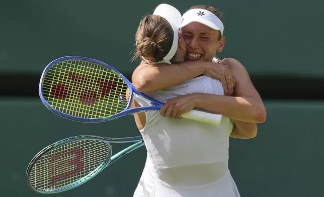 Russia's Veronika Kudermetova, left, and Elise Mertens of Belgium celebrate after beating Su-Wei Hsieh of Taiwan and Latvia's Jelena Ostapenko to win the women's doubles final at the Wimbledon Tennis Championships in London, Sunday, July 13, 2025. (AP Photo/Kin Cheung)