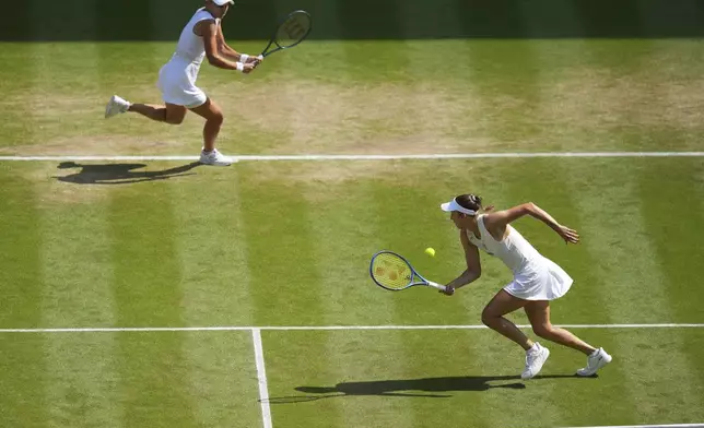 Veronika Kudermetova of Russia, left, and Elise Mertens of Belgium return to Jelena Ostapenko of Latvia and Su-Weih Hsieh of Taiwan during the women's doubles final match at the Wimbledon Tennis Championships in London, Sunday, July 13, 2025.(AP Photo/Joanna Chan)