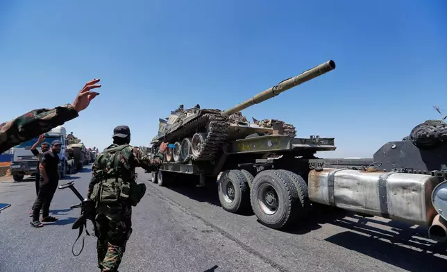A tank for the Syrian government forces carried on a truck, which withdraw from Sweida city, pass on Daraa highway, southern Syria, Tuesday, July 15, 2025. (AP Photo/Omar Sanadiki)