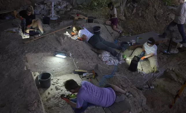 Volunteers work in Tinshemet Cave, where archaeologists are excavating one of the world's oldest known burial sites, dating back 100,000 years, near Shoam, Israel, Tuesday, July 15, 2025. (AP Photo/Ariel Schalit)