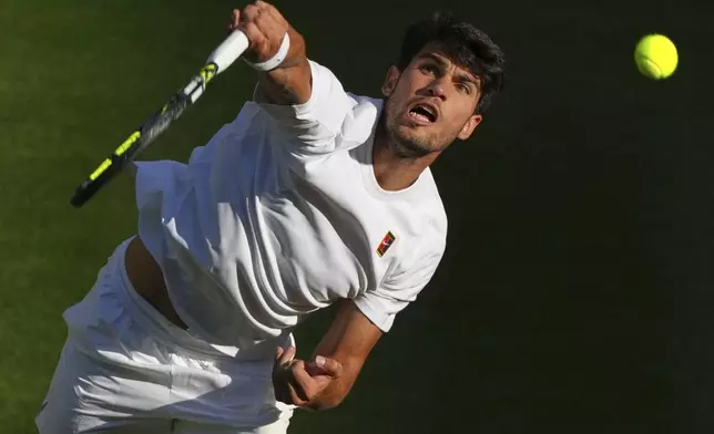 Spain's Carlos Alcaraz serves to Britain's Cameron Norrie during a quarterfinal men's singles match at the Wimbledon Tennis Championships in London, Tuesday, July 8, 2025. (AP Photo/Joanna Chan)