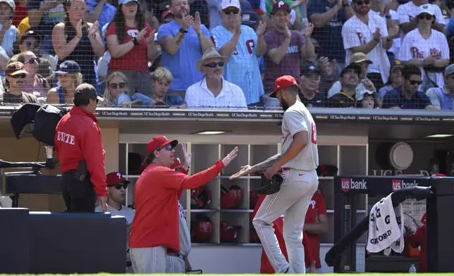 Philadelphia Phillies starter Cristopher Sanchez, front right, is greeted at the dugout after a pitching change in the eighth inning of a baseball game against the San Diego Padres, Sunday, July 13, 2025, in San Diego. (AP Photo/Orlando Ramirez)