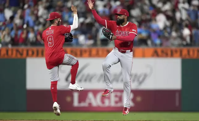 Los Angeles Angels center fielder Jo Adell, right, and shortstop Zach Neto celebrate after the Angels won a baseball game against the Philadelphia Phillies Friday, July 18, 2025, in Philadelphia. (AP Photo/Matt Slocum)