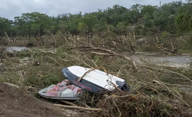 Damaged boats and debris litter the banks of the Guadalupe River near Cade Loop on Saturday, July 5, 2025, in Ingram, Texas. (AP Photo/Rodolfo Gonzalez)