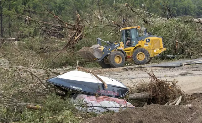 Crews work to clear debris from the Cade Loop bridge along the Guadalupe River on Saturday, July 5, 2025, in Ingram, Texas. (AP Photo/Rodolfo Gonzalez)