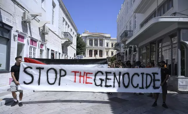 Protesters demonstrate against the departure of a cruise ship carrying Israeli tourists on the Aegean Sea island of Syros, Greece, Tuesday, July 22, 2025. (Nikos Panagiotopoulos/InTime News via AP)