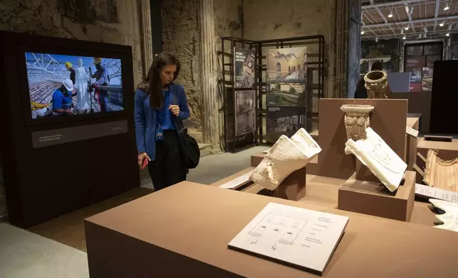 A visitor looks at an exhibit during a press tour at the National Museum ahead of its temporary reopening to the public following a 2018 fire, in Rio de Janeiro, Monday, June 30, 2025. (AP Photo/Bruna Prado)