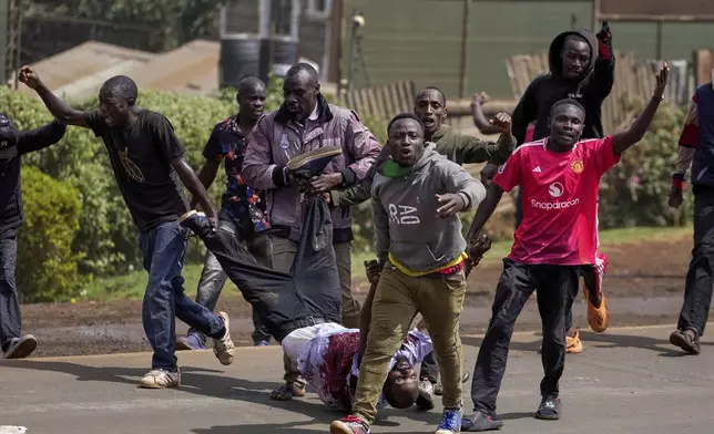 Protester carry a man who the crowd claimed had been shot by police, during the historic 1990 Saba Saba, a Swahili word that means seven seven, protests for democratic reforms in the Kangemi slum of Nairobi, Kenya Monday, July 7, 2025. (AP Photo/Brian Inganga)