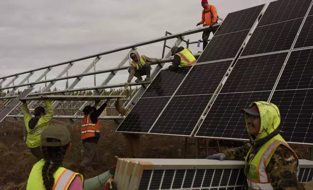 FILE - Workers install panels at a solar project May 21, 2025, in Galena, Alaska. (AP Photo/John Locher, File)