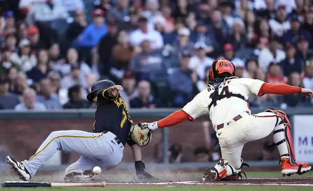 Pittsburgh Pirates' Isiah Kiner-Falefa, left, scores as San Francisco Giants catcher Patrick Bailey is unable to hang on to the ball on the throw from left fielder Heliot Ramos during the second inning of a baseball game Monday, July 28, 2025, in San Francisco. (AP Photo/Godofredo A. Vásquez)