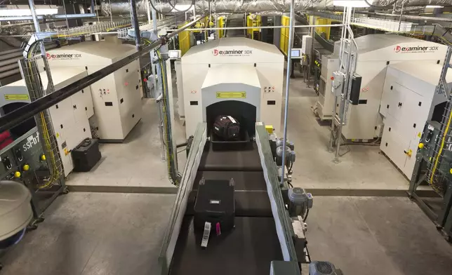 FILE - Air travelers' bags ride a conveyor into one of three new advanced in-line screening machines at Bill and Hillary Clinton National Airport in Little Rock, Ark., Oct. 16 2012. (AP Photo/Danny Johnston, File)