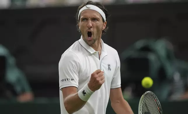 Arthur Rinderknech of France reacts after winning a point against Alexander Zverev of Germany in their first round men's singles match at the Wimbledon Tennis Championships in London, Monday, June 30, 2025. (AP Photo/Alastair Grant)