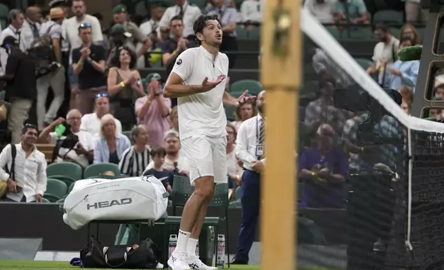 Taylor Fritz of the U.S. reacts after the first round men's single match against Giovanni Mpetshi Perricard of France was suspended at the Wimbledon Tennis Championships in London, Monday, June 30, 2025. (AP Photo/Kin Cheung)
