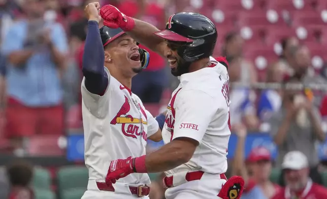 St. Louis Cardinals' Jose Fermin, right, is congratulated by teammate Masyn Winn after hitting a two-run home run during the sixth inning of a baseball game against the Atlanta Braves Sunday, July 13, 2025, in St. Louis. (AP Photo/Jeff Roberson)