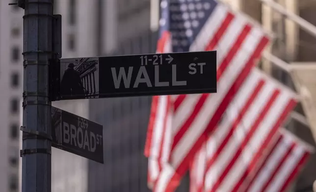 Wall Street sign hangs next to the New York Stock Exchange on Monday, June 30, 2025, in New York. (AP Photo/Yuki Iwamura)