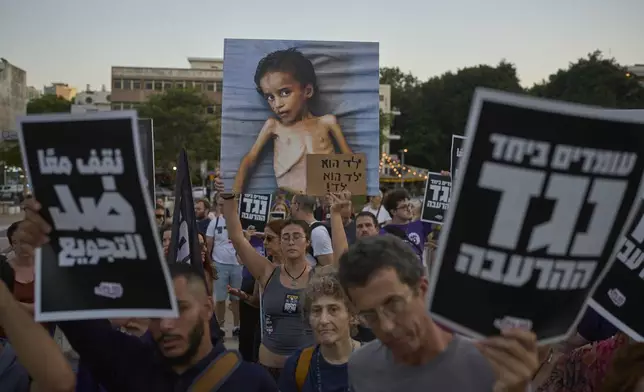 Israeli activists take part in a protest against the war in the Gaza Strip, Israel's measures regarding food distribution and the forced displacement of Palestinians, in Tel Aviv, Israel, Tuesday, July 22, 2025. (AP Photo/Ohad Zwigenberg)