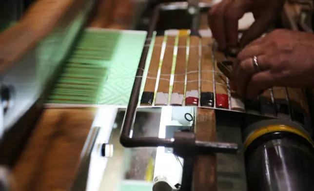 Hironori Fukuoka, the fourth-generation successor to his Nishijinori business, works on the fabric that is a collaboration with AI in Kyoto, western Japan on July 3, 2025. (AP Photo/Yuri Kageyama)