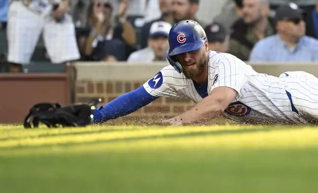 Chicago Cubs' Michael Busch scores during the second inning of a baseball game against the Cleveland Guardians, Tuesday, July 1, 2025, in Chicago. (AP Photo/Matt Marton)