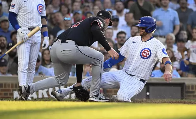 Chicago Cubs' Carson Kelly is tagged out at home plate by Cleveland Guardians catcher Bo Naylor during the second inning of a baseball game, Tuesday, July 1, 2025, in Chicago. (AP Photo/Matt Marton)
