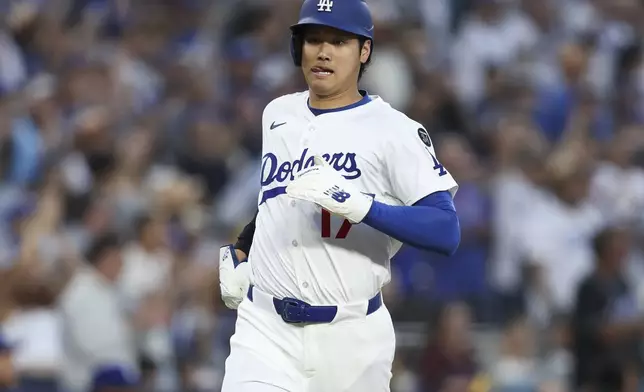 Los Angeles Dodgers designated hitter Shohei Ohtani runs toward home plate to score during the third inning of a baseball game against the Chicago White Sox, Thursday, July 3, 2025, in Los Angeles. (AP Photo/Jessie Alcheh)
