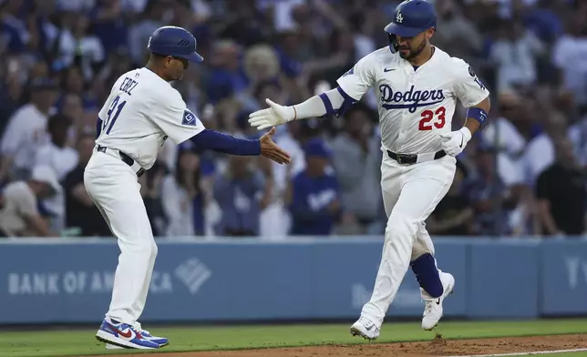 Los Angeles Dodgers' Michael Conforto (23) celebrates with third base coach coach Dino Ebel, left, after hitting a home run during the third inning of a baseball game against the Chicago White Sox, Thursday, July 3, 2025, in Los Angeles. (AP Photo/Jessie Alcheh)