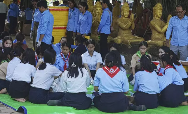 Local students wrap food to give to villagers while they take refuge in Buddhist pagoda in Srey Snam district, Siem Reap province, Cambodia, Sunday, July 28, 2025, amid the fighting between Thailand and Cambodia. (AP Photo/Heng Sinith)