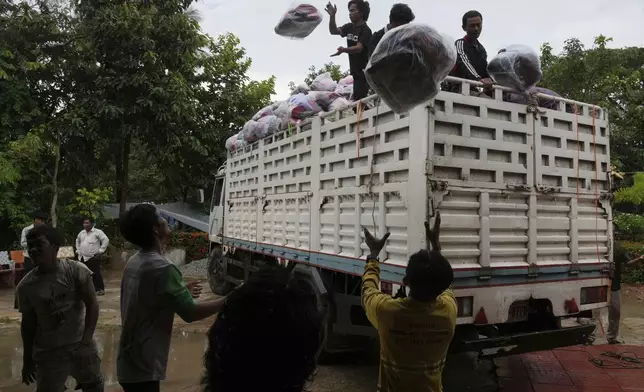 Local villagers help unloading supplies donated by a charity for refugees from a truck, in Srey Snam district, Siem Reap province, Cambodia, Monday, July 28, 2025, amid the fighting between Thailand and Cambodia. (AP Photo/Heng Sinith)