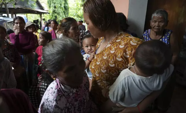 Local villagers wait to receive supplies donated by a charity, in Srey Snam district, Siem Reap province, Cambodia, Monday, July 28, 2025, amid the fighting between Thailand and Cambodia. (AP Photo/Heng Sinith)