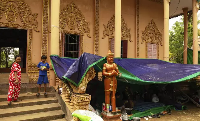 Peoples who are displaced by the conflict between Thailand and Cambodia stand near their makeshift tent at a resettlement camp in Siem Reap, Cambodia on Monday, July 28, 2025. (AP Photo/Anton L. Delgado)