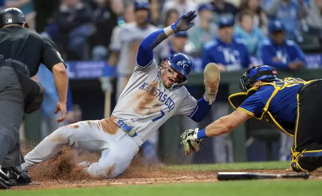 Kansas City Royals' Bobby Witt Jr. (7) avoids the tag of Seattle Mariners catcher Cal Raleigh to score a run during the seventh inning of a baseball game, Thursday, July 3, 2025, in Seattle. (AP Photo/Stephen Brashear)