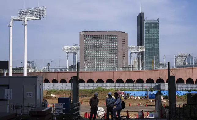 Workers at a construction site near the Jingu stadium in Tokyo, Wednesday, July 3, 2025. (AP Photo/Louise Delmotte)