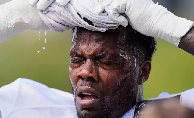 Tennessee Titans linebacker Arden Key uses a wet towel to cool off after practice at the team's NFL football training camp, Tuesday, July 29, 2025, in Nashville, Tenn. (AP Photo/George Walker IV)