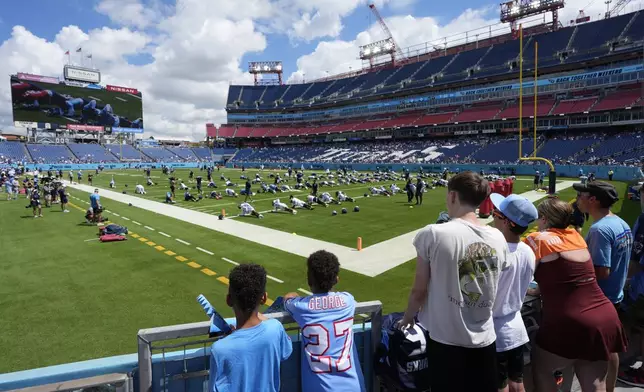 Fans watch the Tennessee Titans stretch during "Back Together Weekend" at the team's NFL football training camp Saturday, July 26, 2025, in Nashville, Tenn. (AP Photo/George Walker IV)