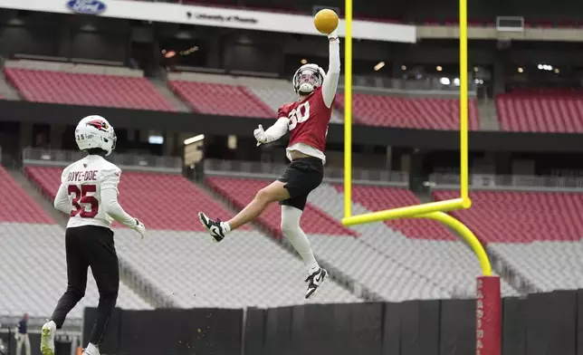 Arizona Cardinals wide receiver Simi Fehoko (80) leaps in front of Cardinals defensive back Ekow Boye-Doe (35) during practice at the team's NFL football training camp Thursday, July 24, 2025, in Glendale, Ariz. (AP Photo/Ross D. Franklin)