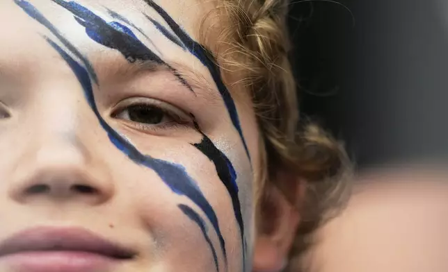 Jaxxon Nehm, 10, poses for a portrait with Detroit Lions themed face paint during Back Together Weekend at NFL football training camp Saturday, July 26, 2025, in Allen Park, Mich. (AP Photo/Ryan Sun)