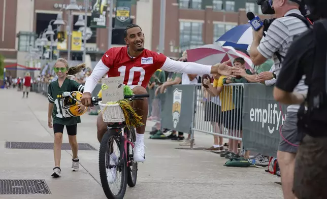 Green Bay Packers' quarterback Jordan Love rides a bike to practice at the team’s NFL football training camp Wednesday, July 23, 2025, in Green Bay, Wis. (AP Photo/Matt Ludtke)